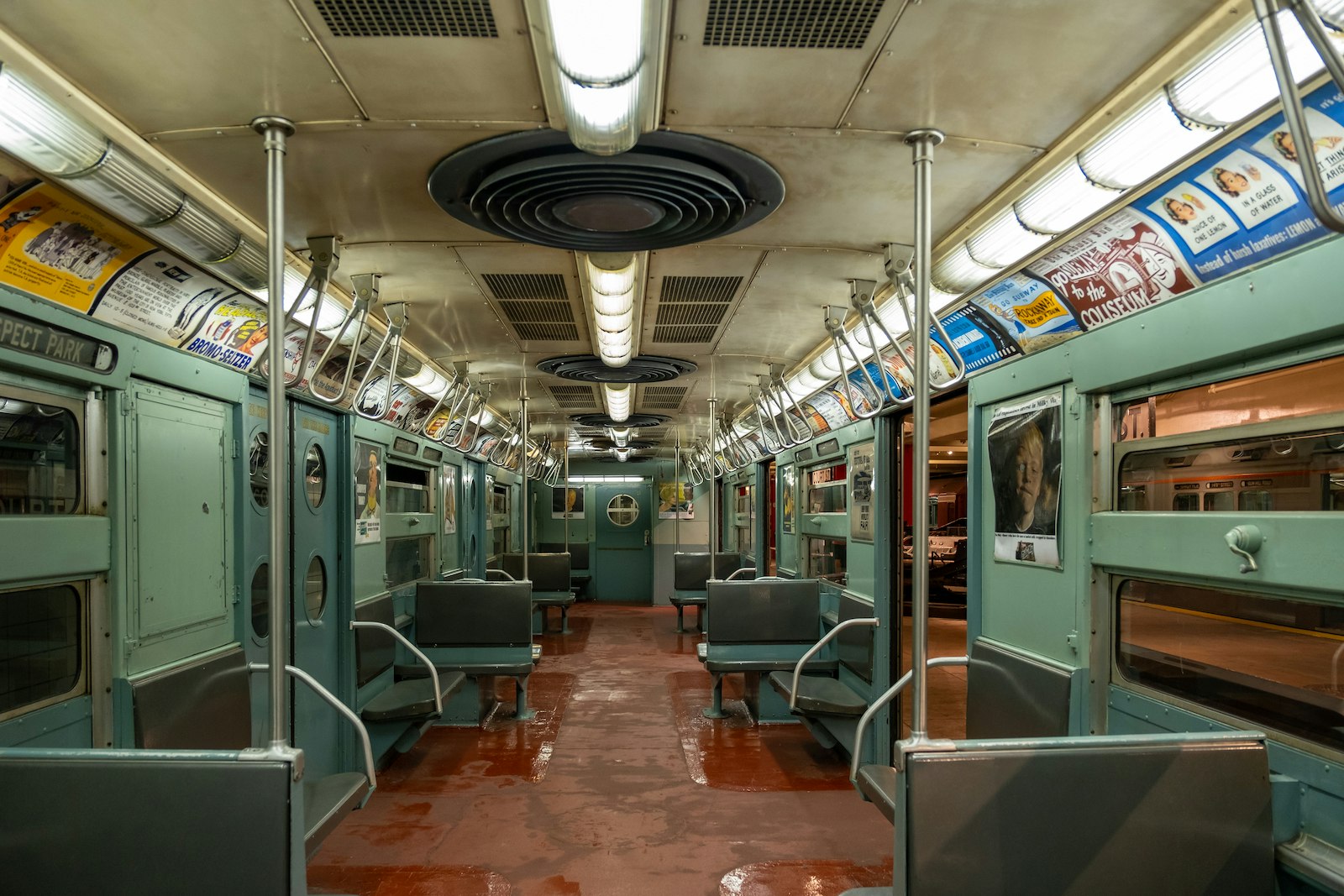 A vintage subway train car featuring teal walls and seats