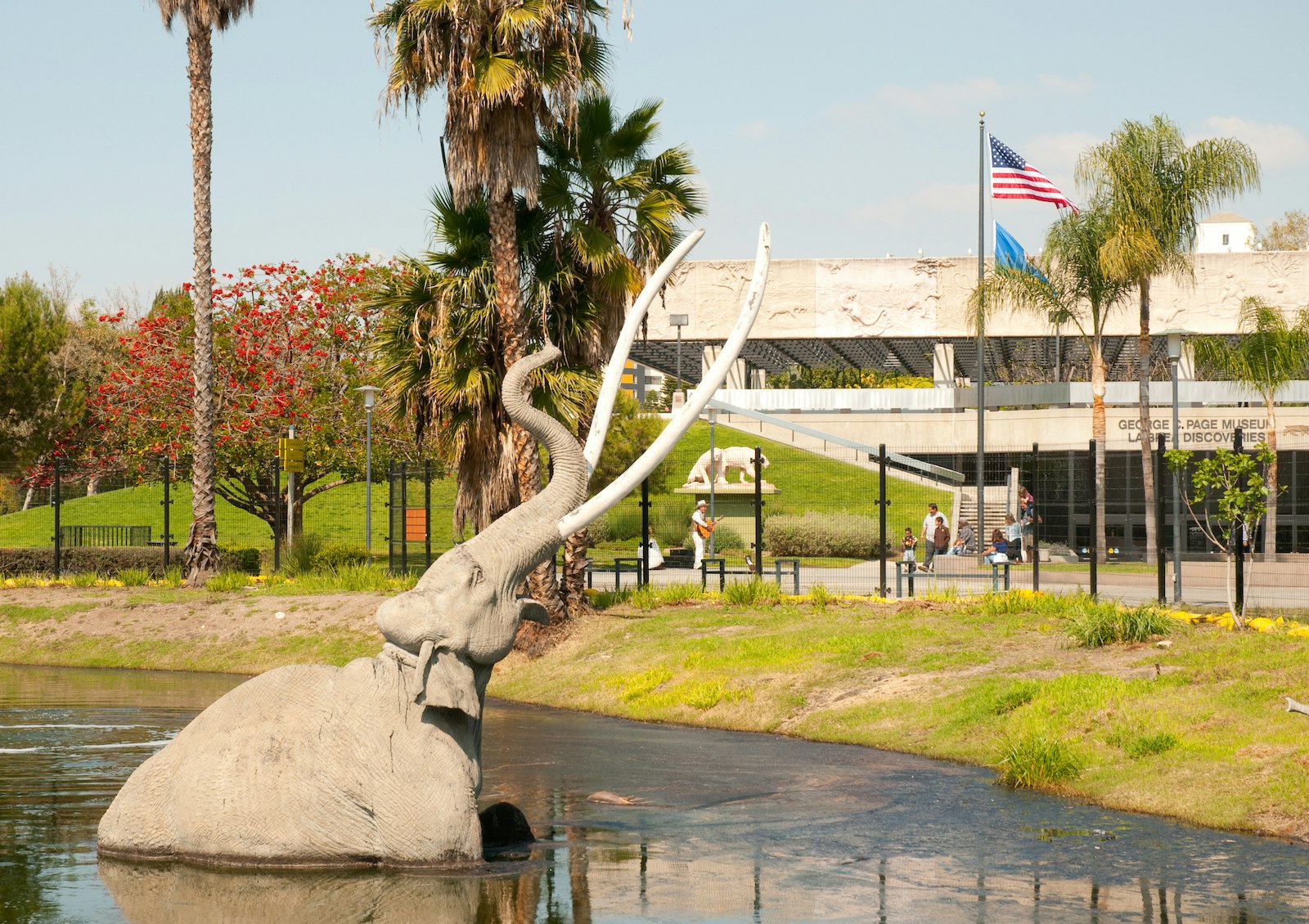 A mammoth sculpture in a tar pit, tusks and trunk pointed at the sky