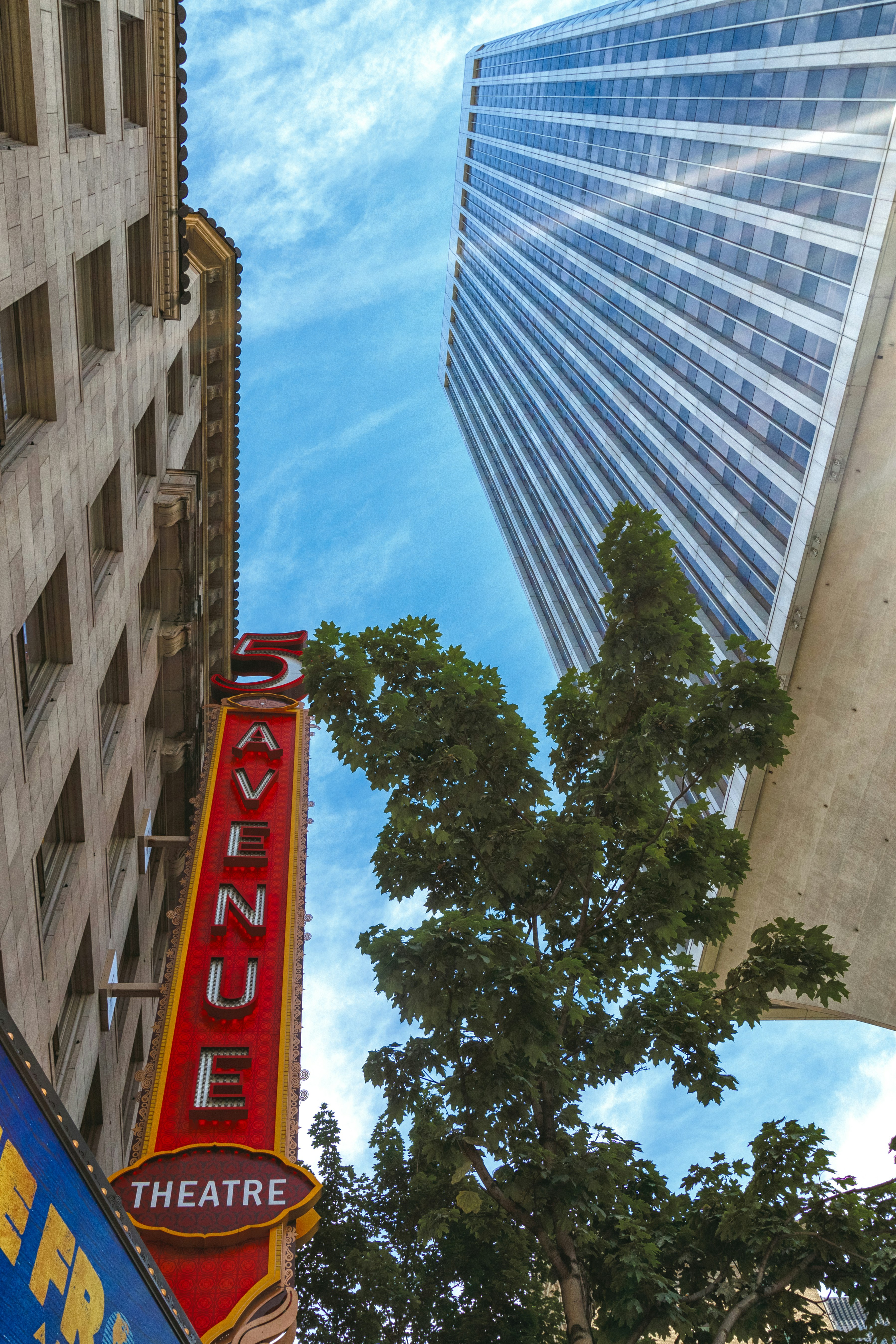 Looking up at the red sign outside the 5th Avenue Theatre and the blue sky above