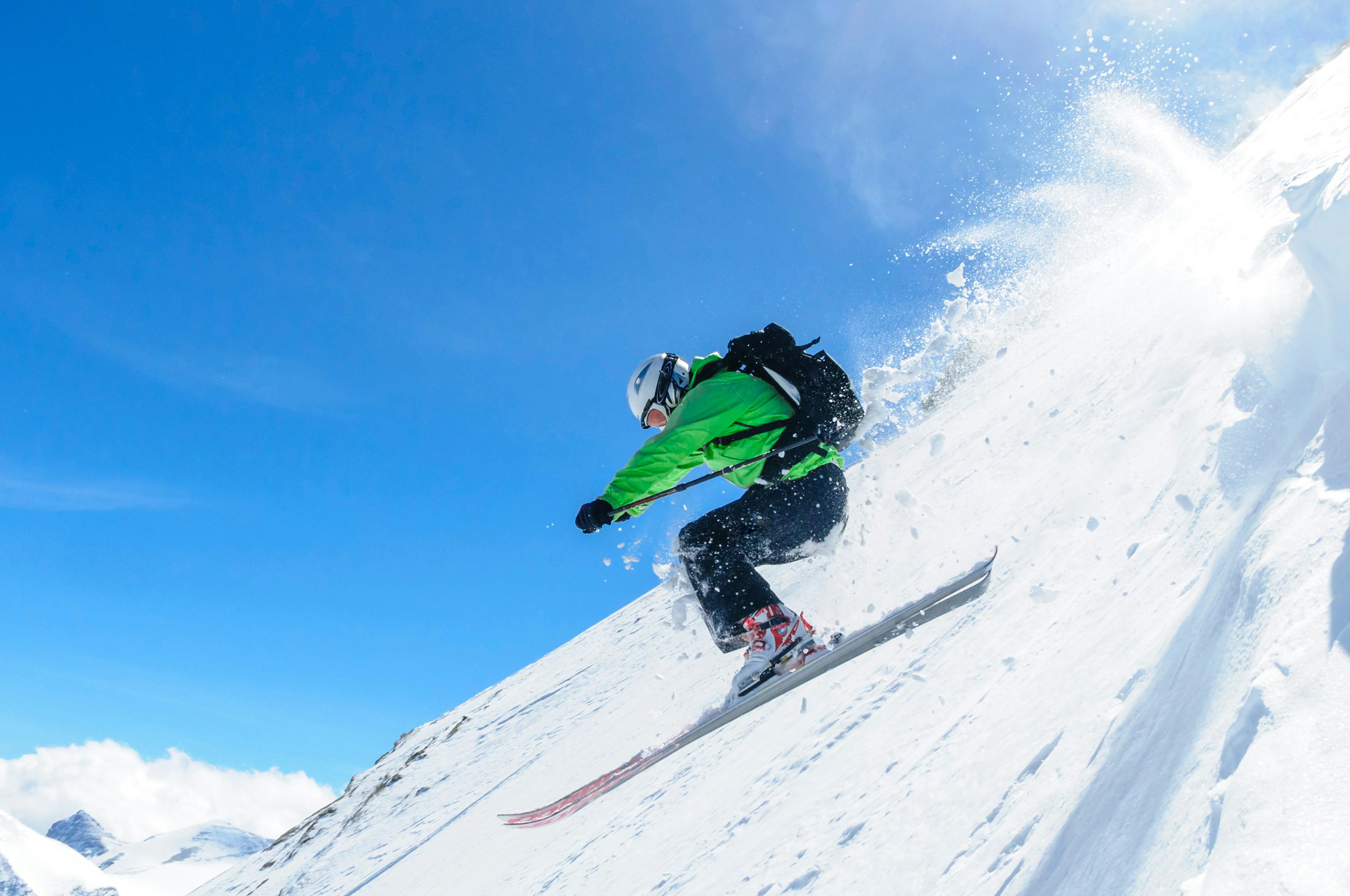 A skier goes downhill surrounded by snow