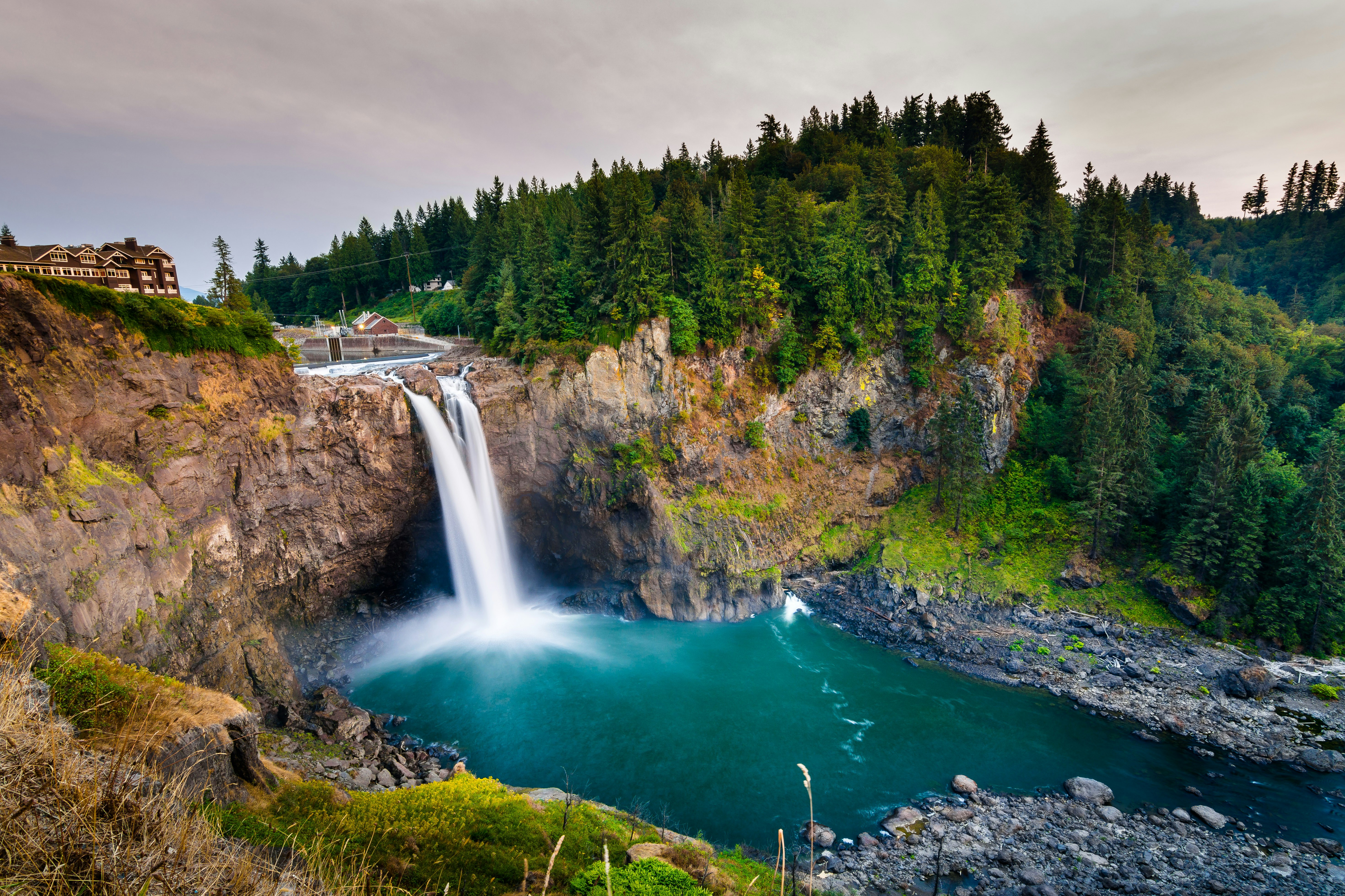 A beautiful waterfall pours into a bright blue pool. 