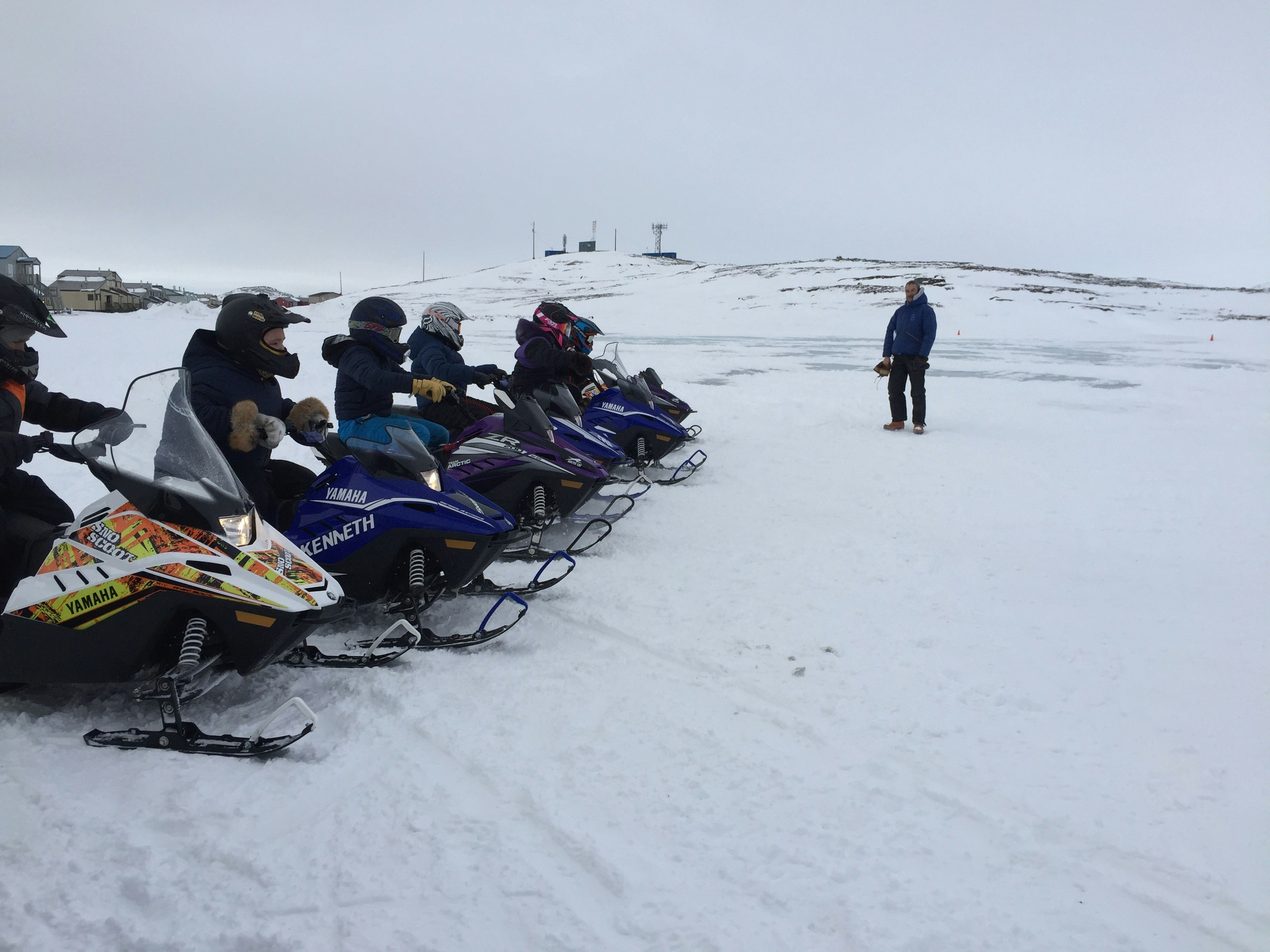 Children on miniature snowmobiles are lined up in a row, ready to begin a race during the Toonik Tyme Festival in Iqaluit.