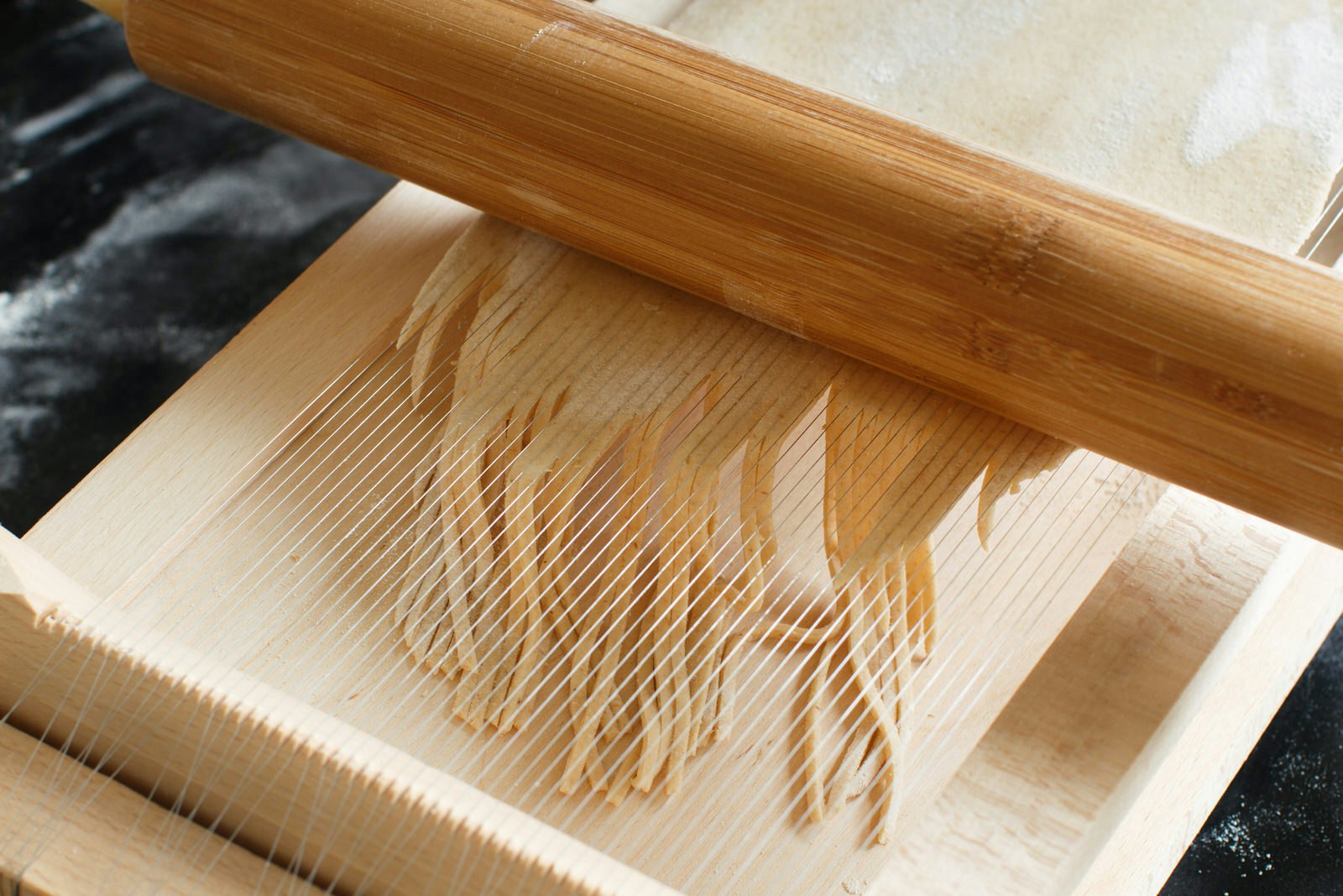 Making spaghetti alla chitarra, an Abruzzo speciality, with a tool that uses very thin guitar-like strings to perfectly slice the pasta