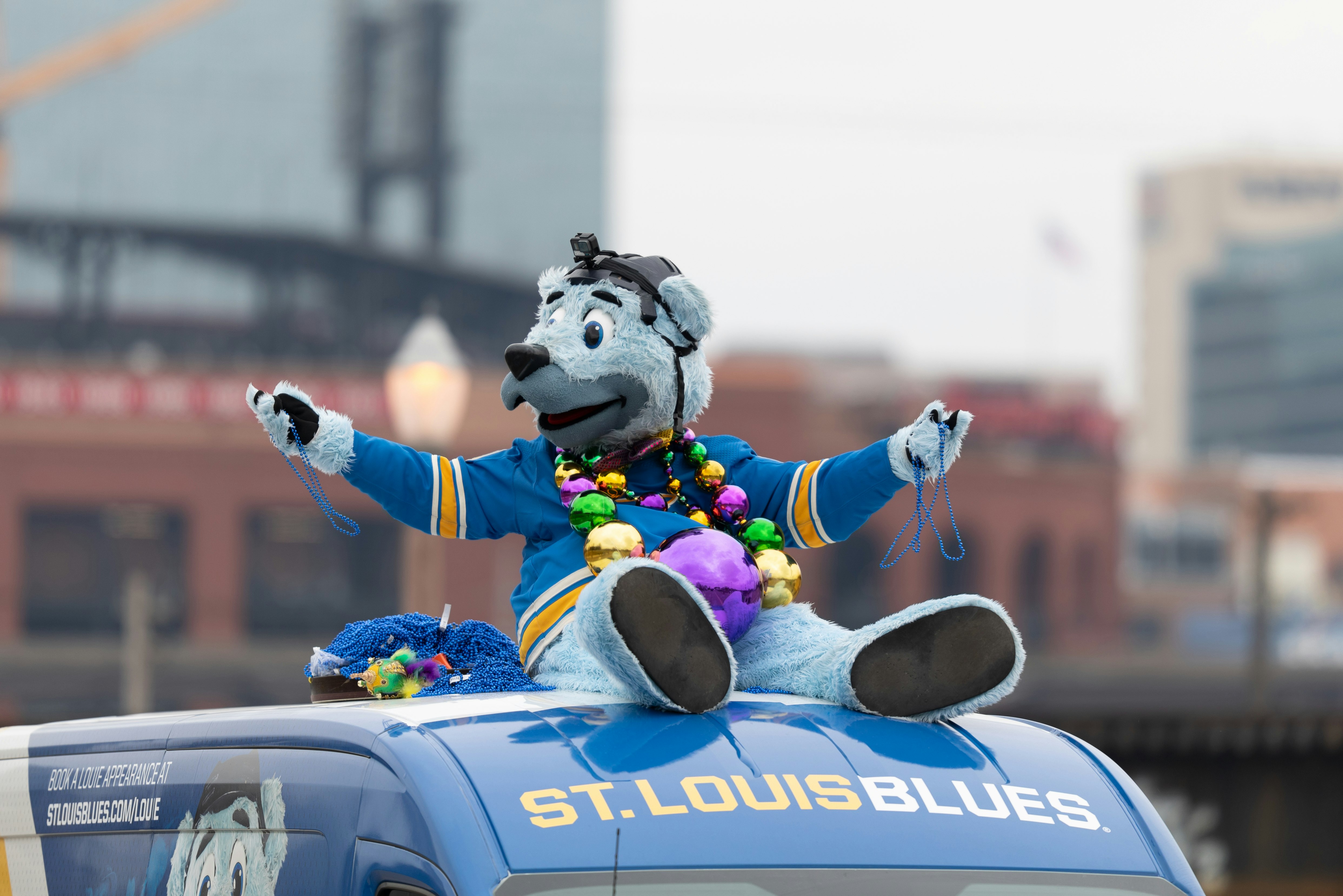 The St Louis Blues mascot riding on top of a vehicle during the Bud Light Grand Parade