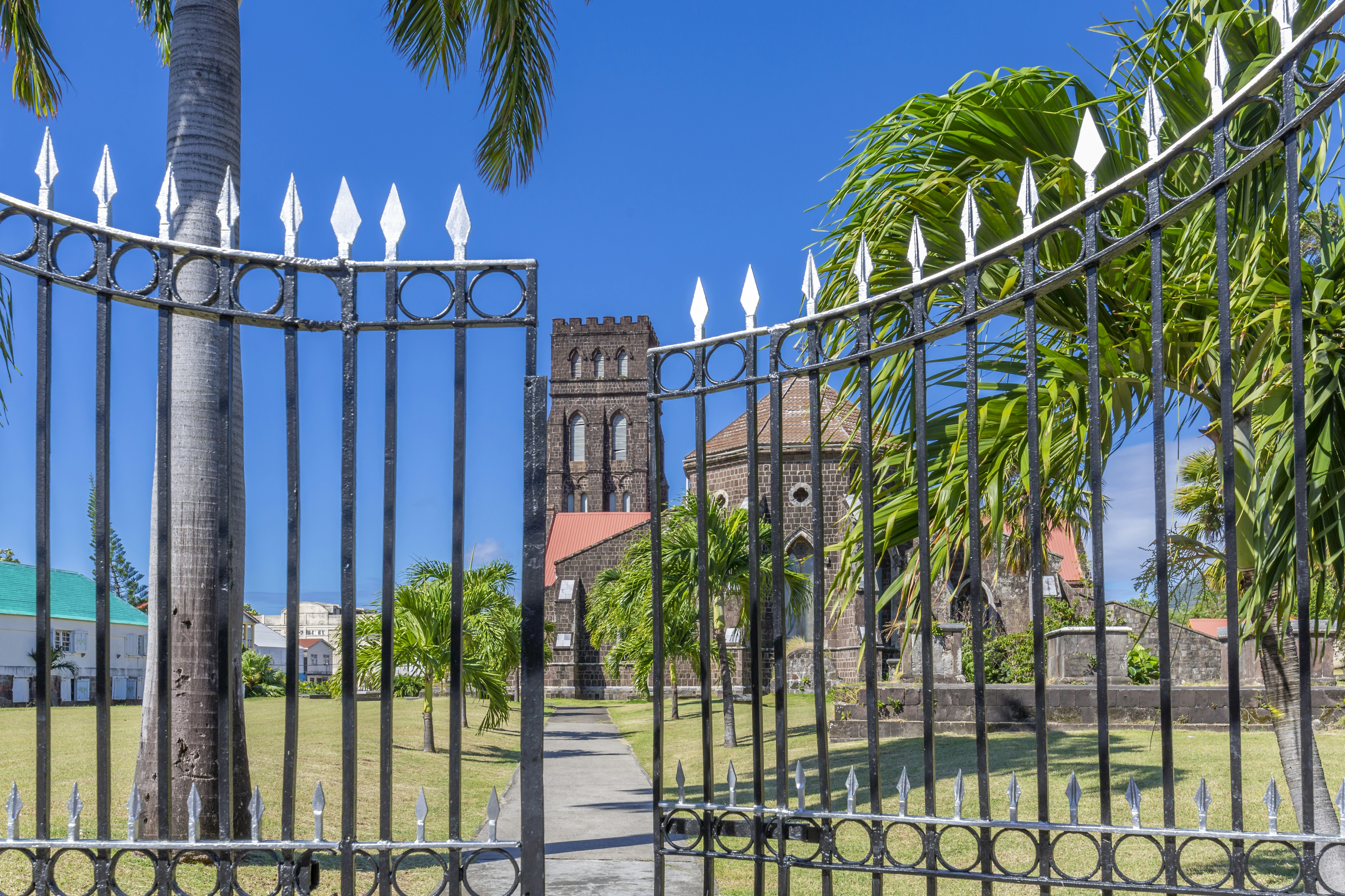 Iron gates are partially open in front of an old stone church