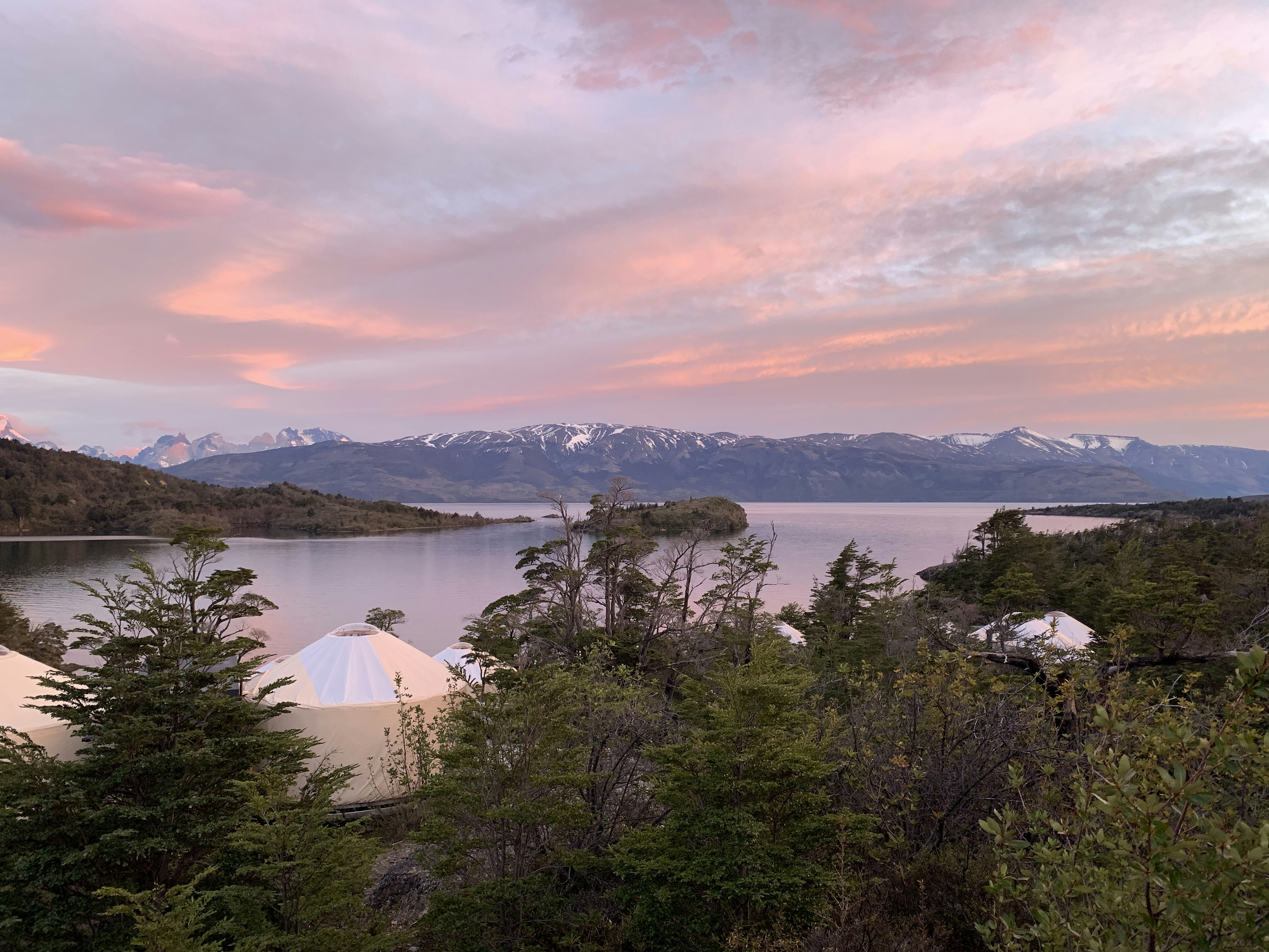 Yurts beside a lake with mountains in the background.JPG