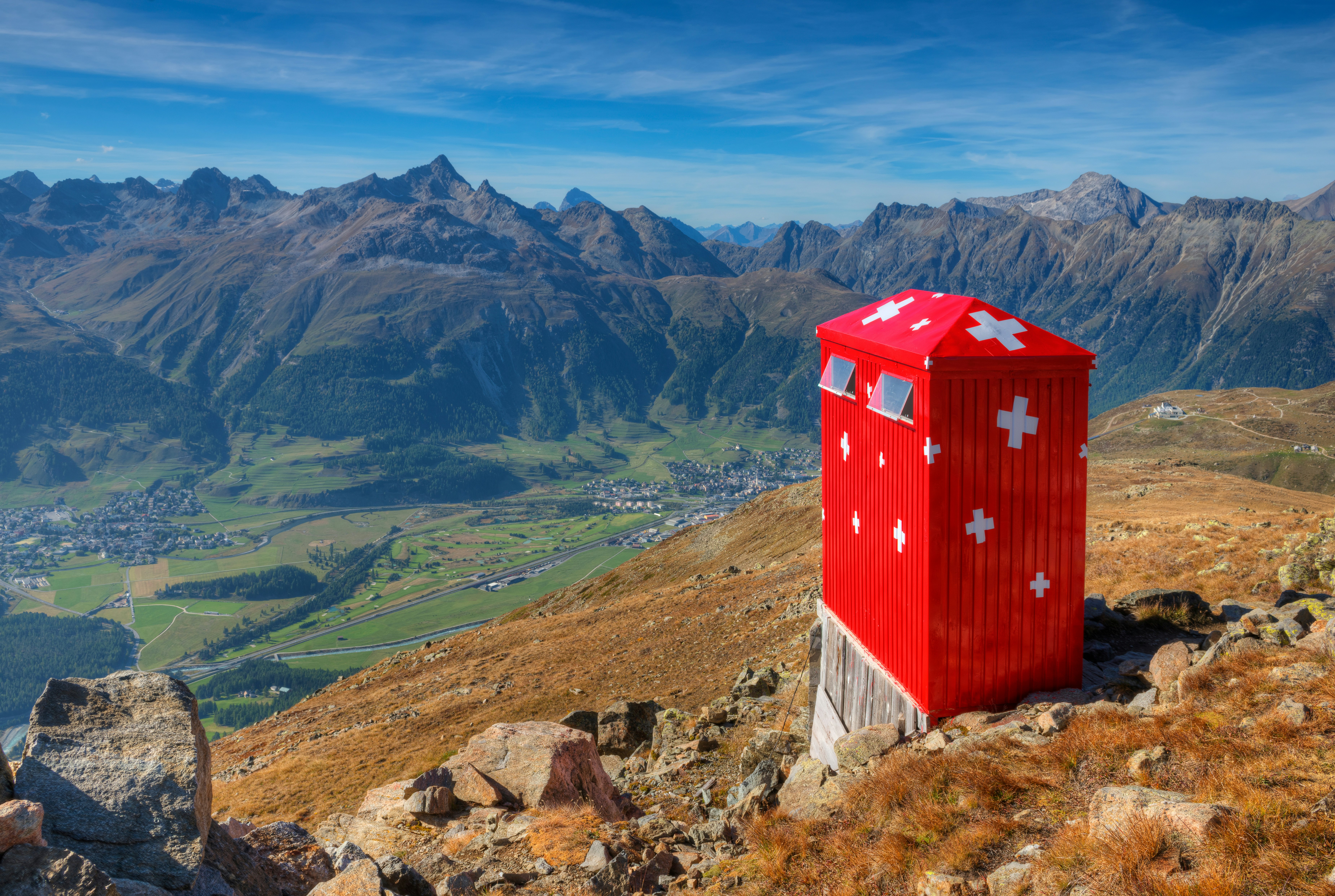 A red toilet overlooking a deep valley