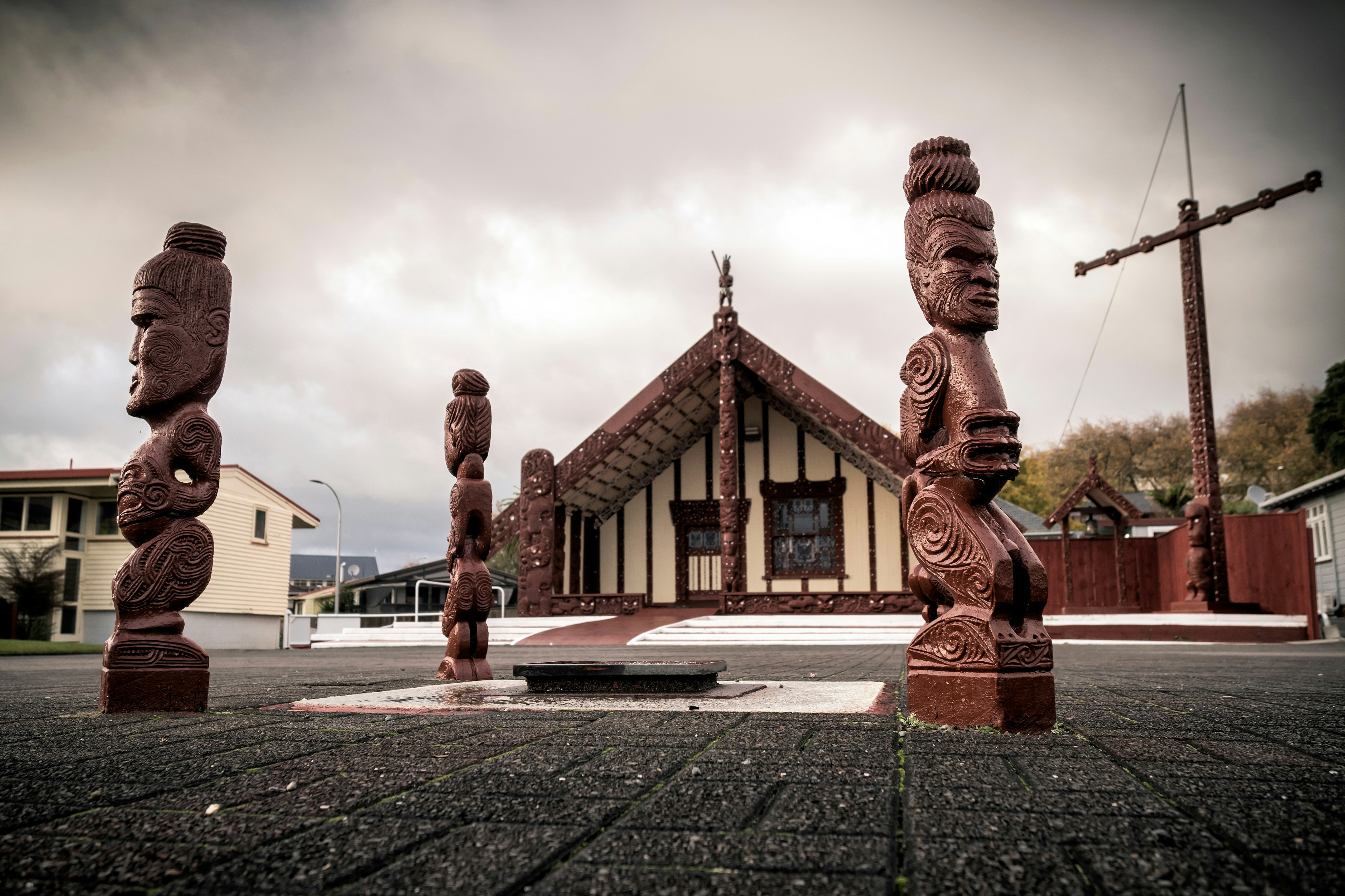 Intricately carved wooden sculptures of people stand outside the Tama-te-Kapua Meeting House in Ohinemutu, Rotorua.