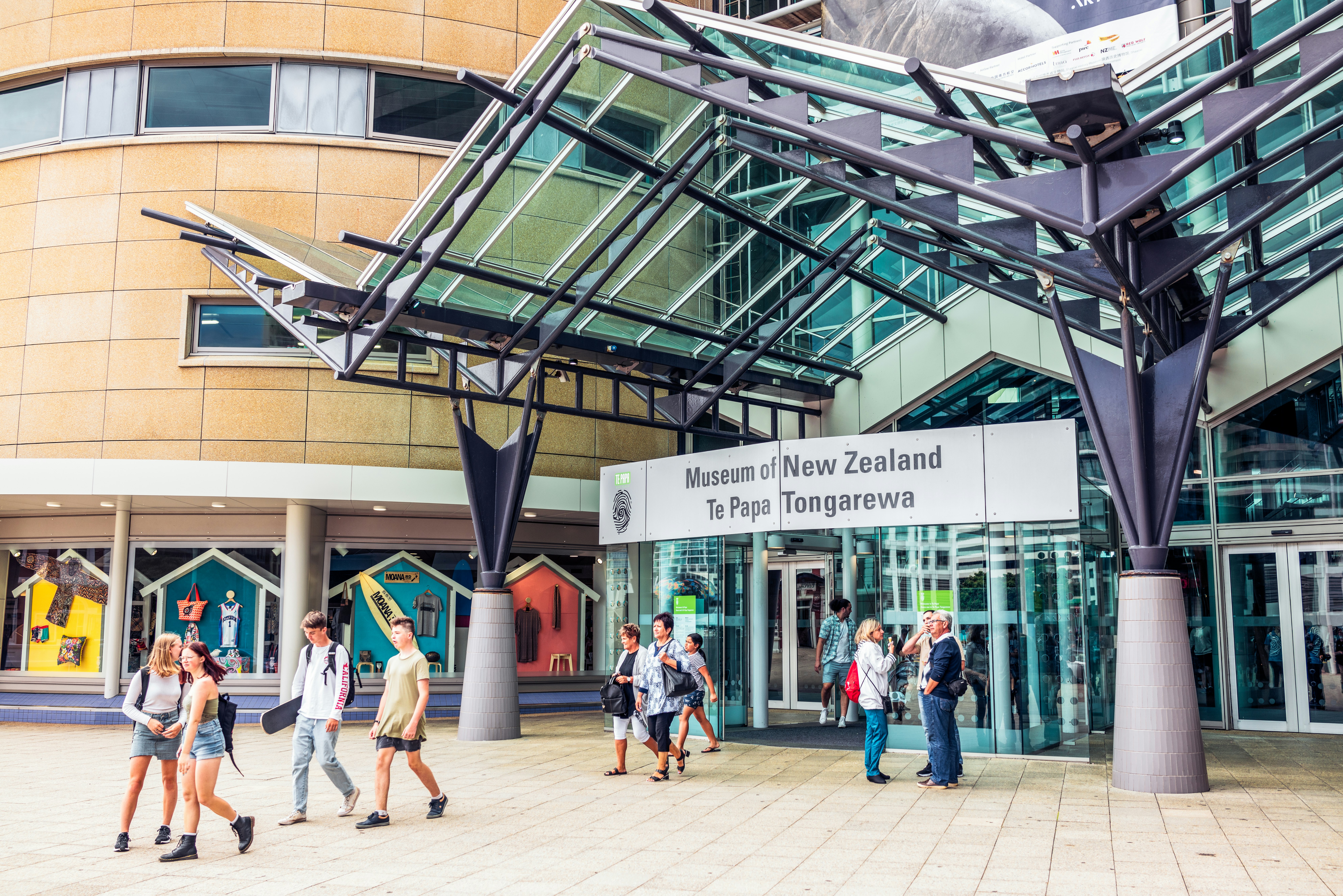 Visitors entering and leaving the Museum of New Zealand in Wellington; the sign also states the Māori name, Te Papa Tongarewa.