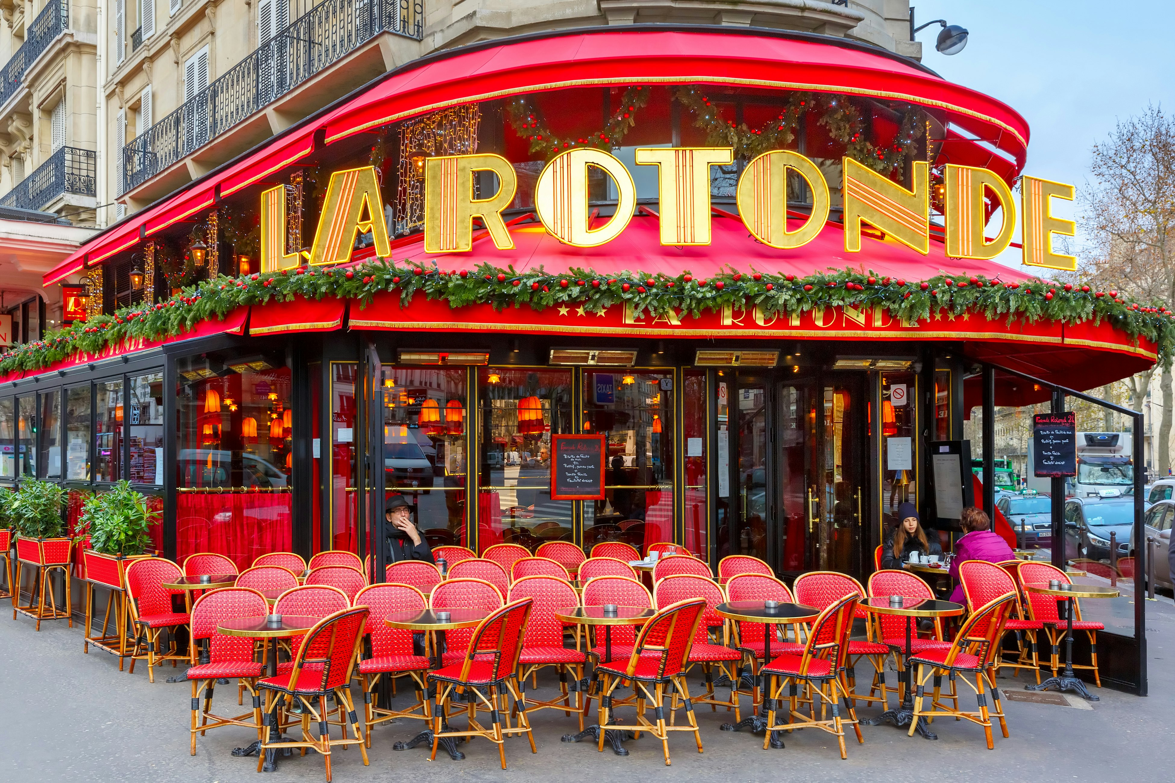 the red chairs and red marquee of La Rotonde of the Montparnasse Quarter in Paris, France