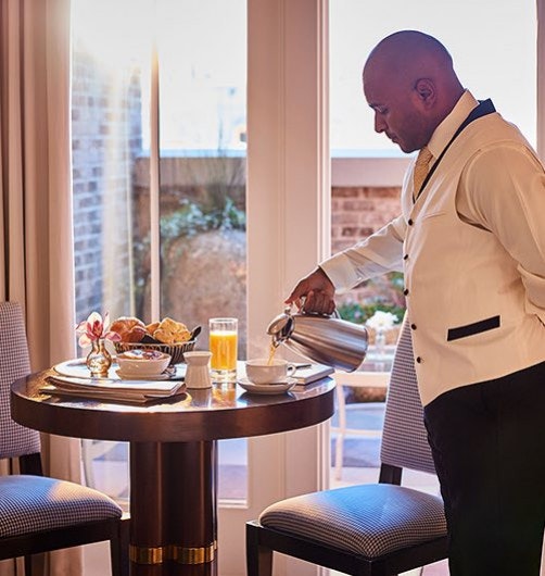 A butler pours coffee into a cup in a suite at the Spectator hotel