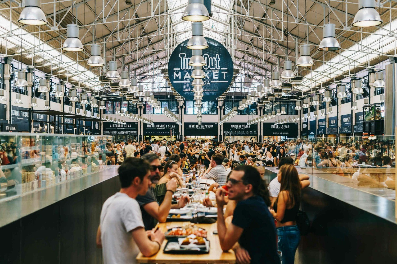 People dining inside the Time Out Market food hall in Mercado da Ribeira in Lisbon.