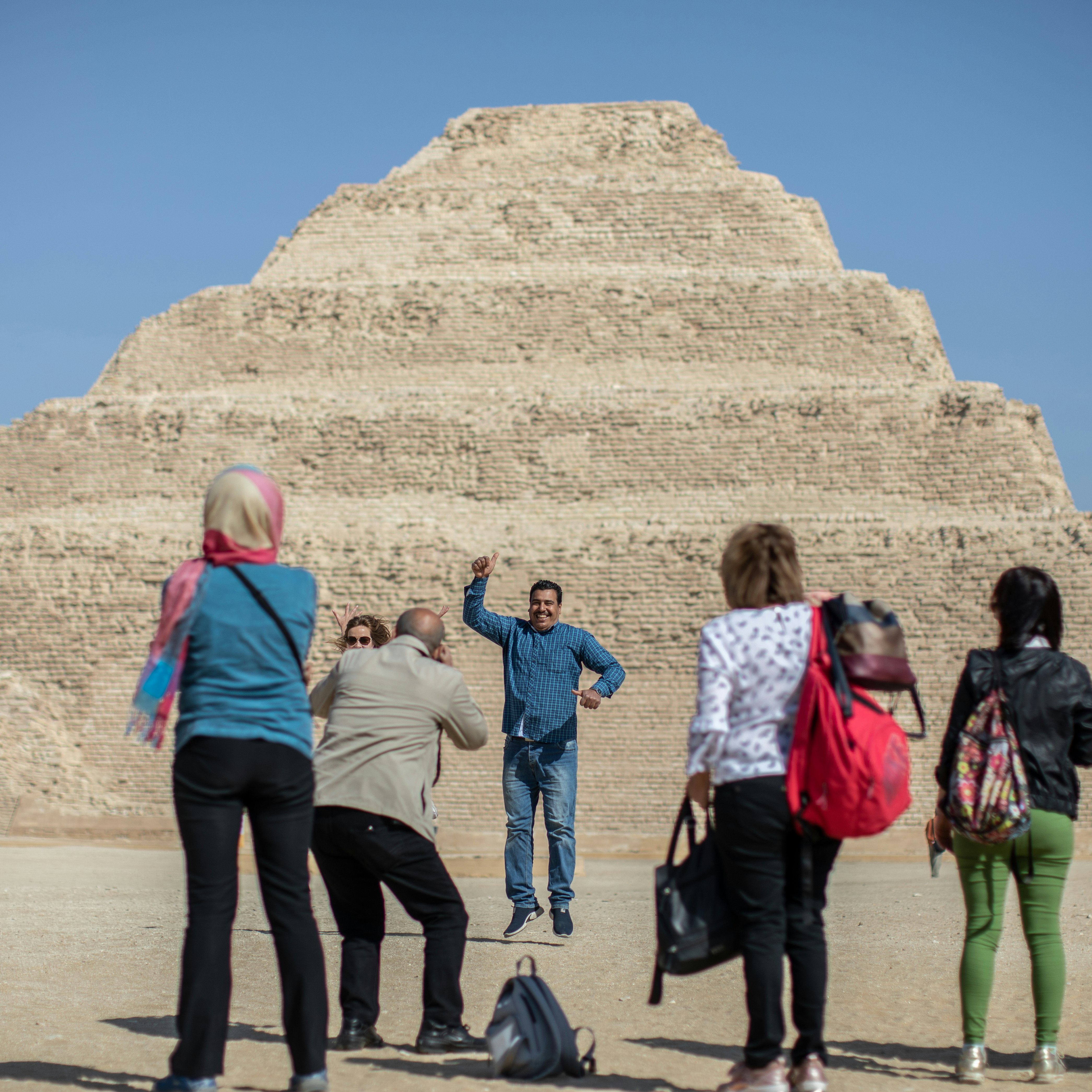 Tourists take souvenir pictures in front of the Pyramid of Djoser in Saqqara outside Cairo. 