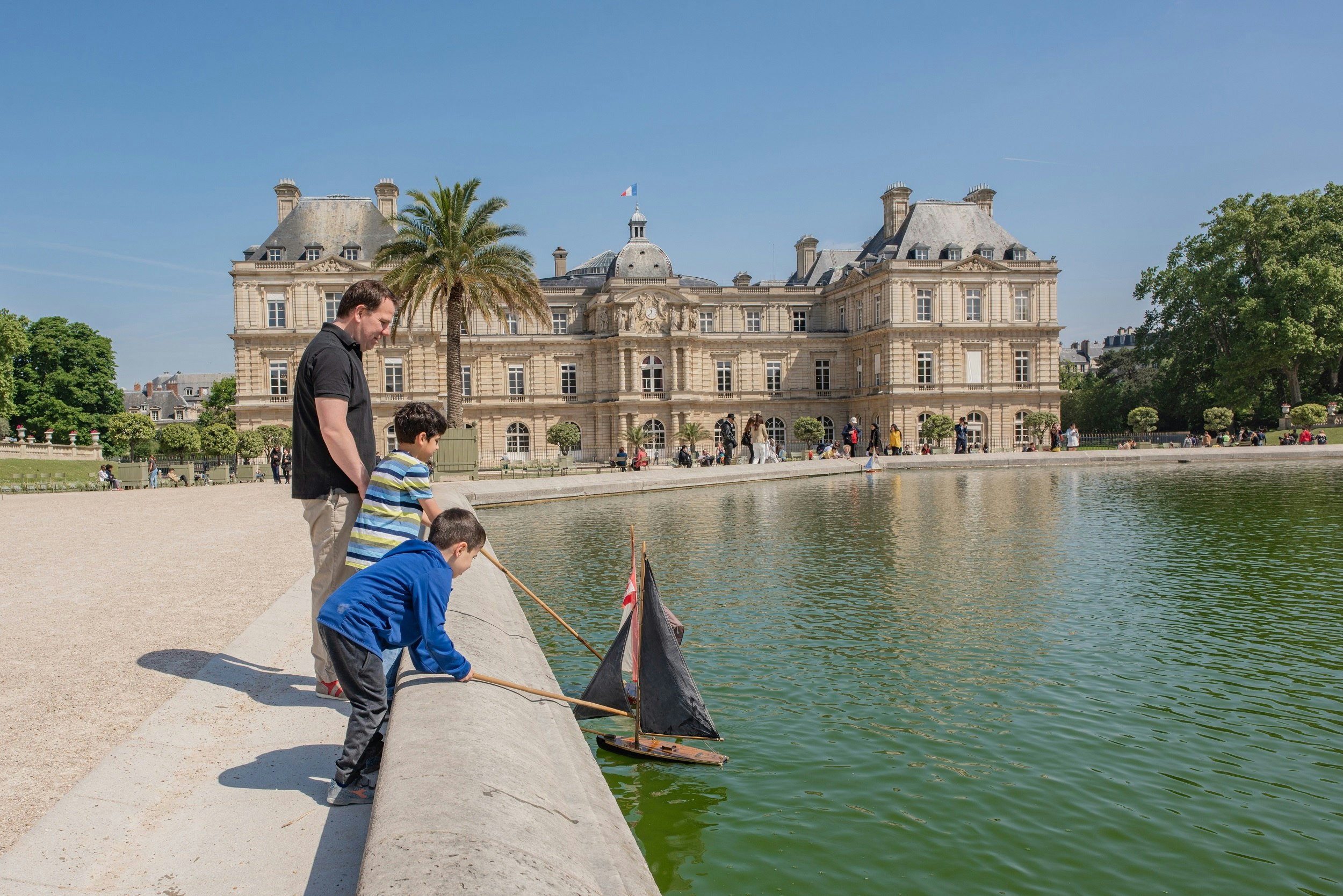 Children play with toy sail boats at the Luxembourg Palace and Gardens in the Montparnasse neighbourhood.