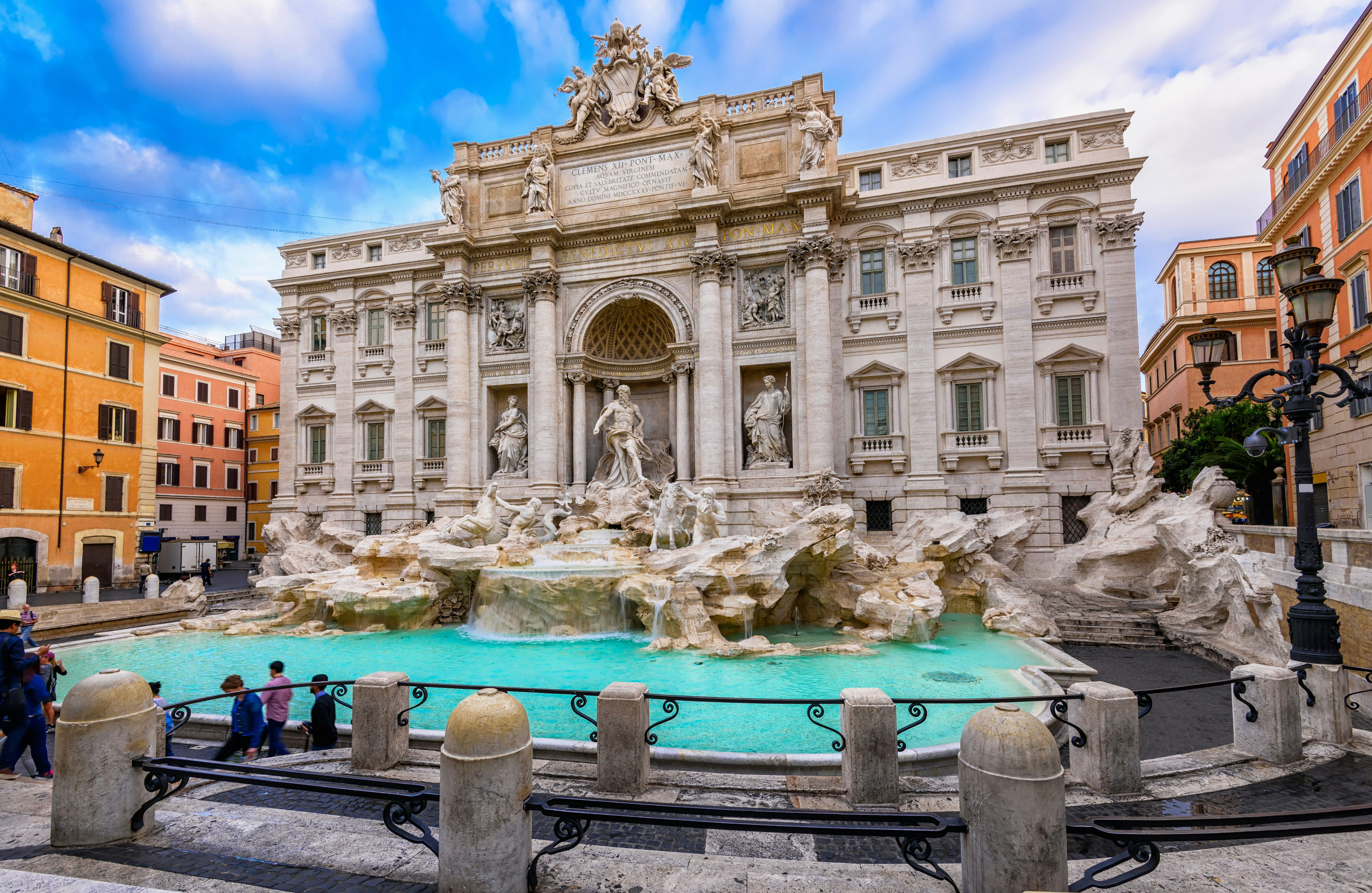 Tourists stand in front of the Trevi Fountain in Rome. 