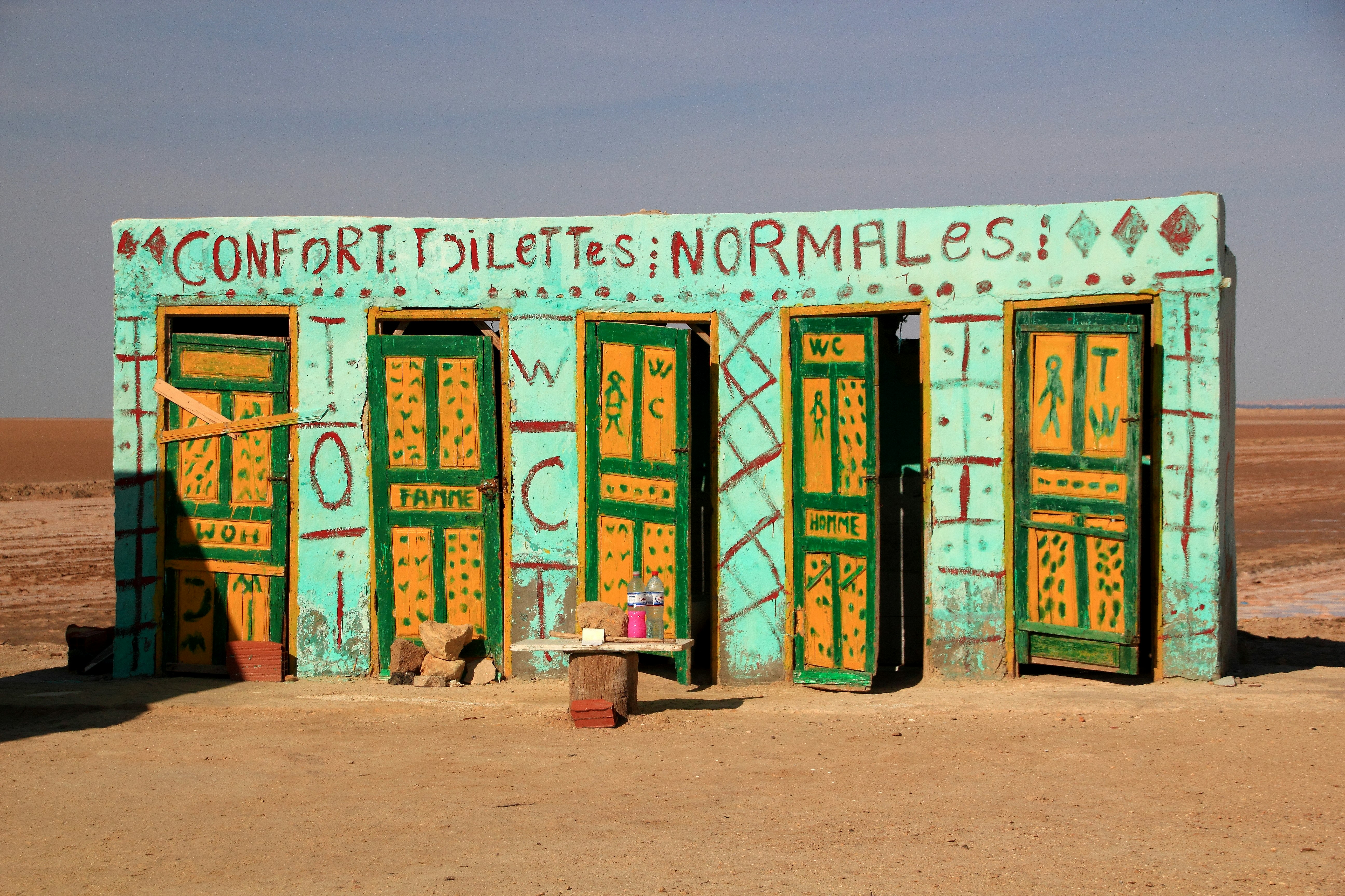 A painted building with a sign reading "Confort Toilettes Normales"