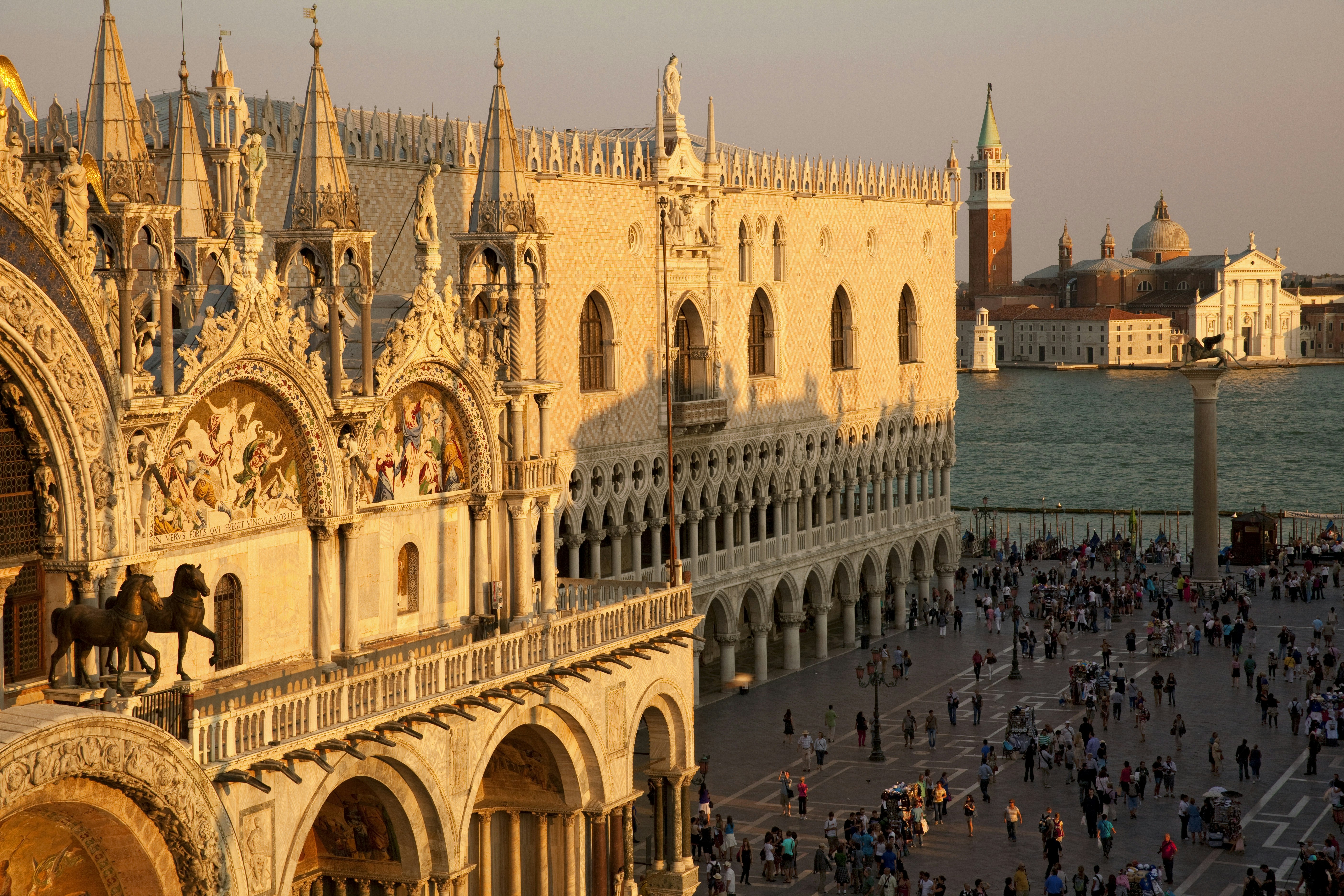 A picture of St. Mark's Basilica taken from above at sunset, with golden light washing over the building