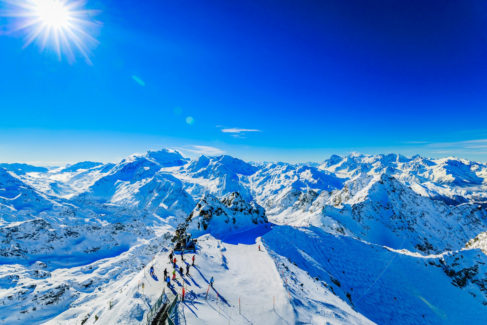 Shot from the summit of Mont Fort, this image shows a horizon full of snow-covered peaks under an incredibly dark blue sky