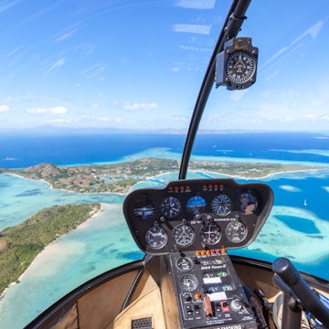Tropical island seen from helicopter cockpit, Malolo Island, Fiji