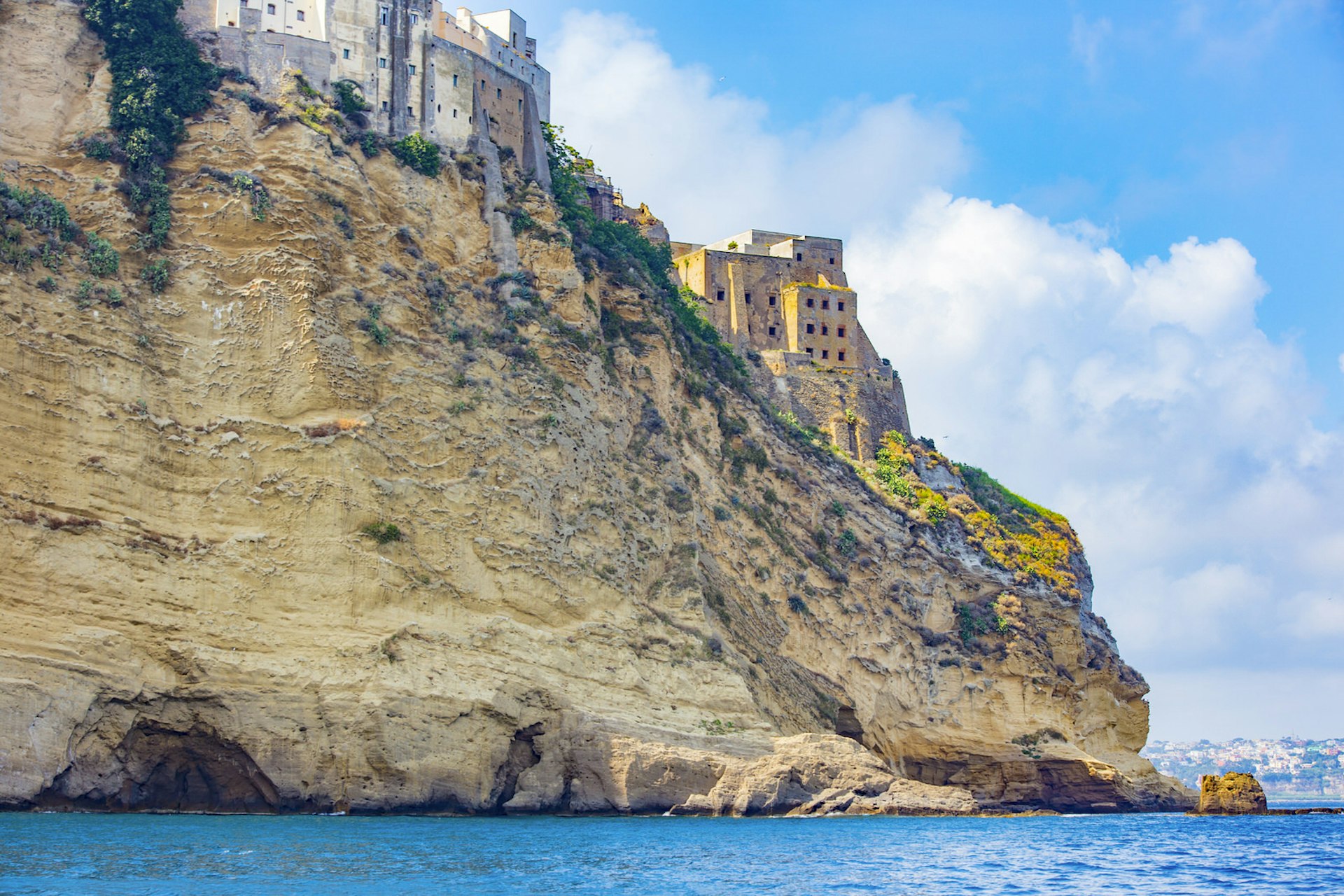 Historic, centuries-old stone buildings cling to the top of vertical cliffs that plunge down into the Mediterranean Sea.