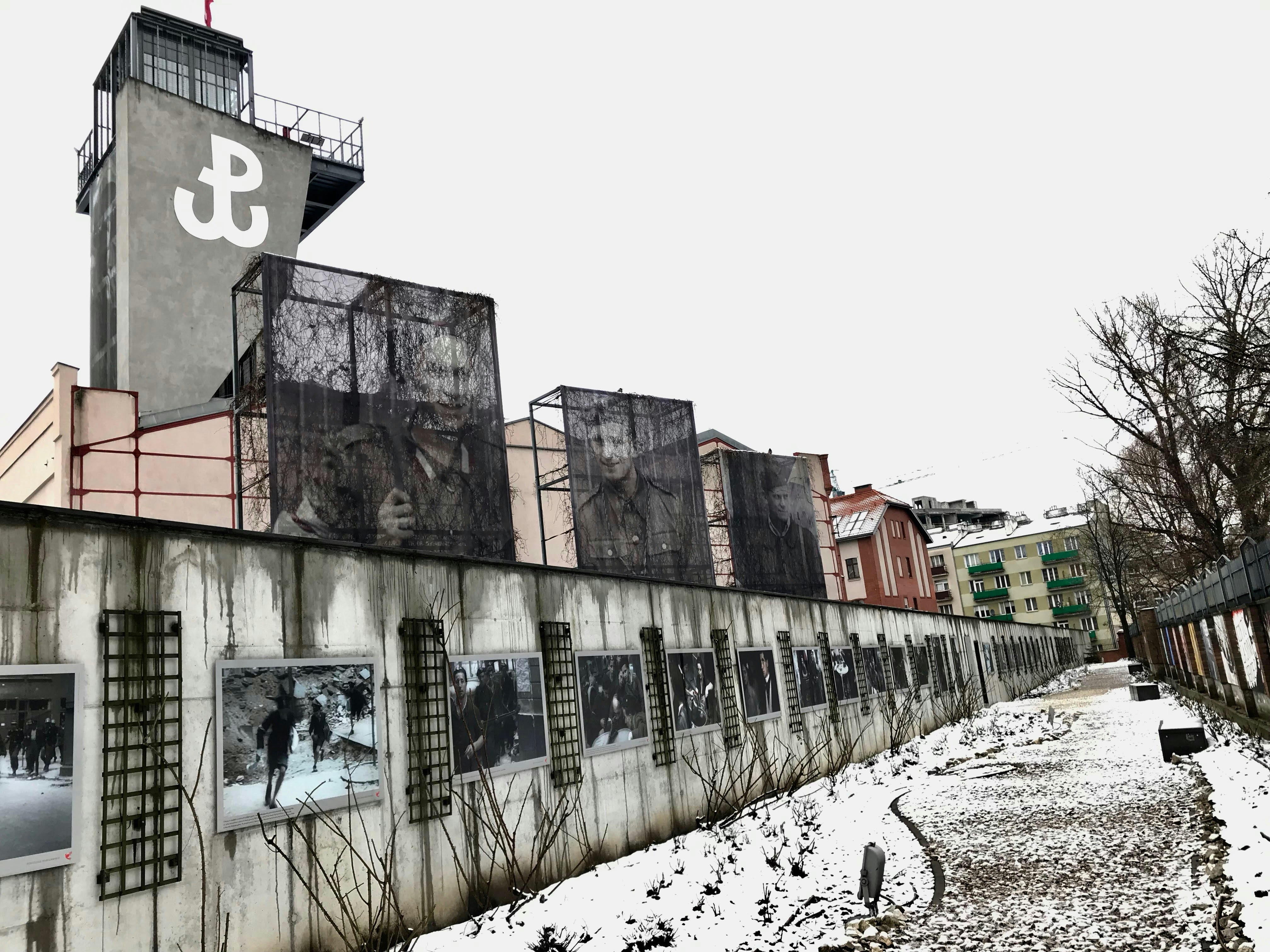 A historic wall is lined with artwork. 