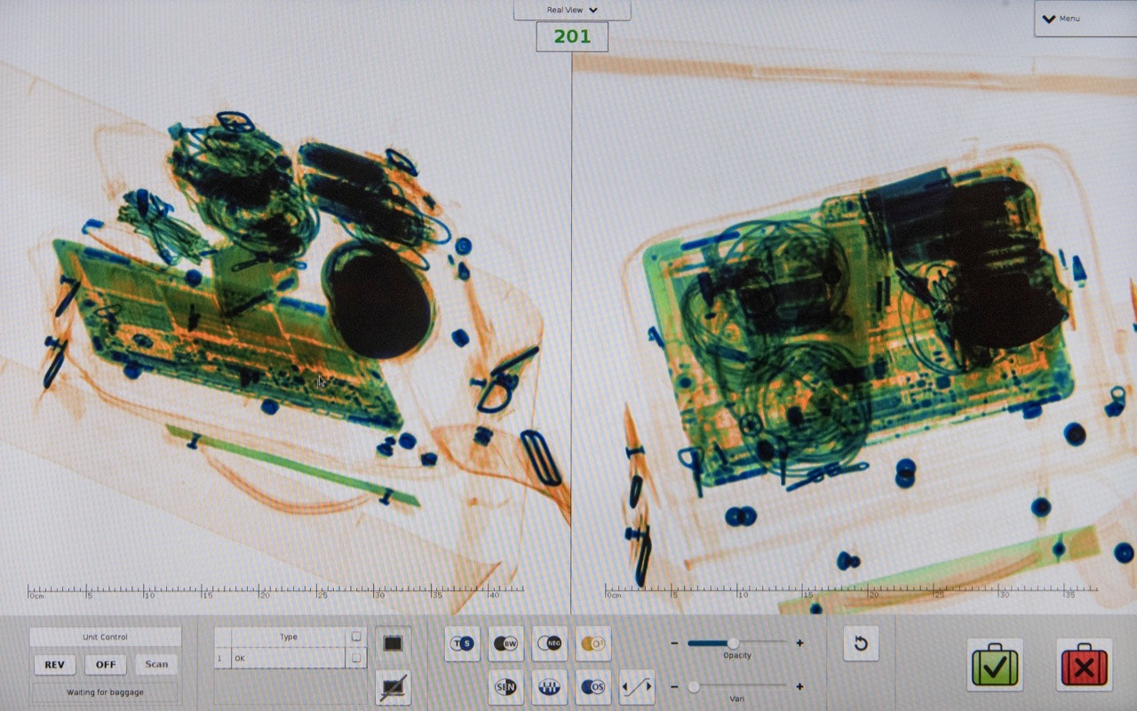 A laptop and other electronic parts are displayed three-dimensionally on the screen of a Smiths Detection baggage scanner.