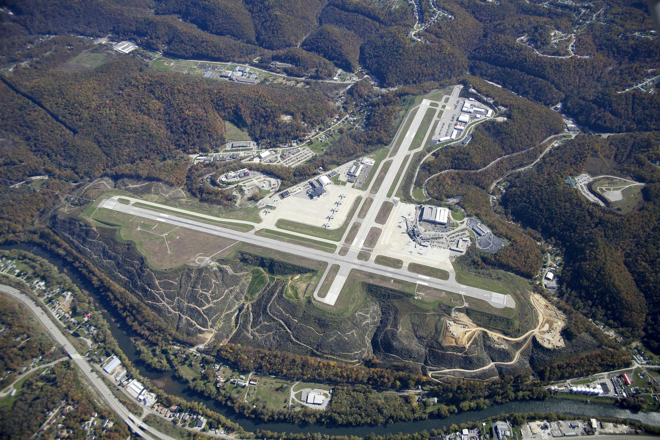 An aerial view of the airfield and airport in Charleston, West Virginia surrounded by gentle rolling hills just barely starting to show the first colors of autumn