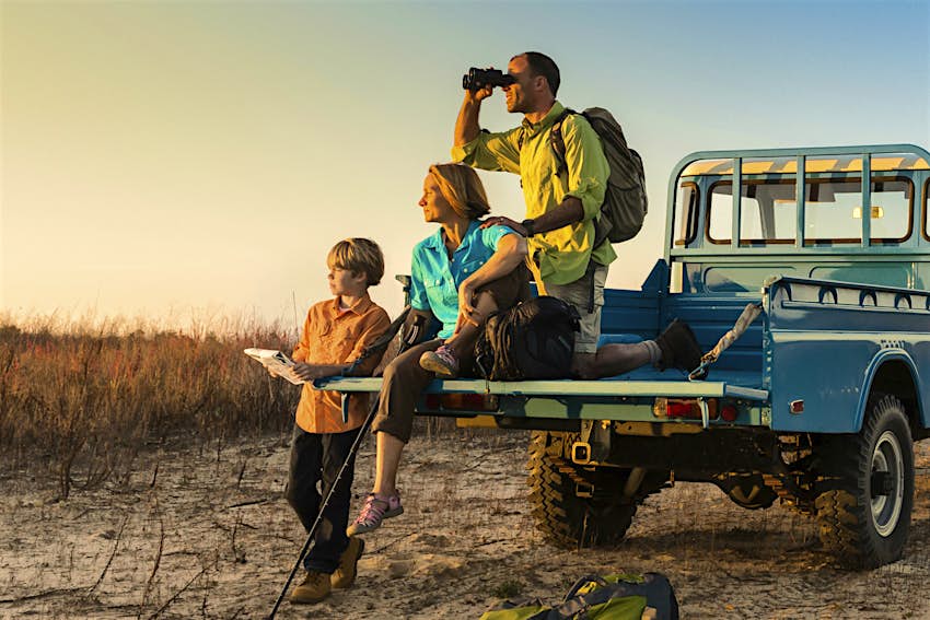 Kids Blog - safe-to-take-kids-on-safari A family on safari, sitting on a jeep looking for wildlife © Steve Cole 178020/Getty Images