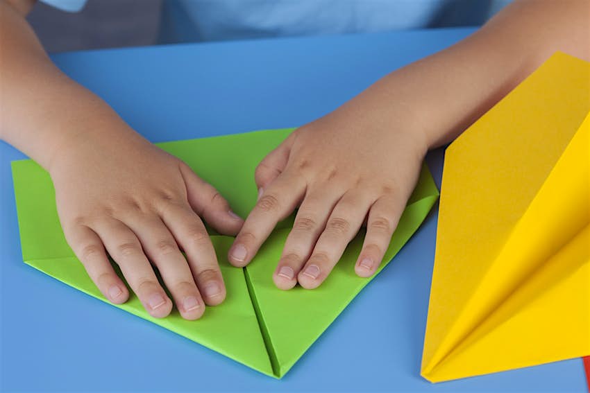 Kids Blog - shutterstock_222012295 A child's hands making a paper airplane