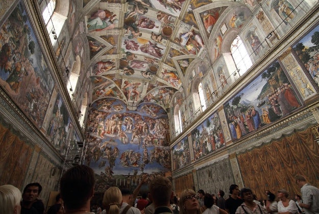Visitors admire the artistry inside the Sistine Chapel.