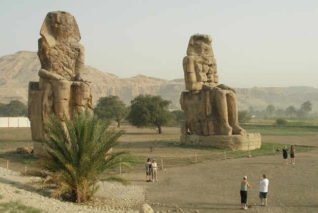 The Colossi of Memnon feature two statues of Amenhotep III seated.