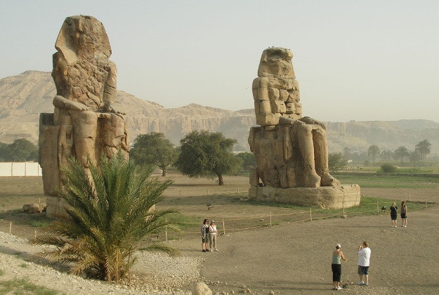 The Colossi of Memnon feature two statues of Amenhotep III seated.