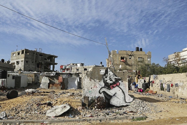 A mural of a playful-looking kitten, painted by British street graffiti artist Banksy, is seen on a wall damaged in last summer's Israel-Hamas war, in Beit Hanoun.