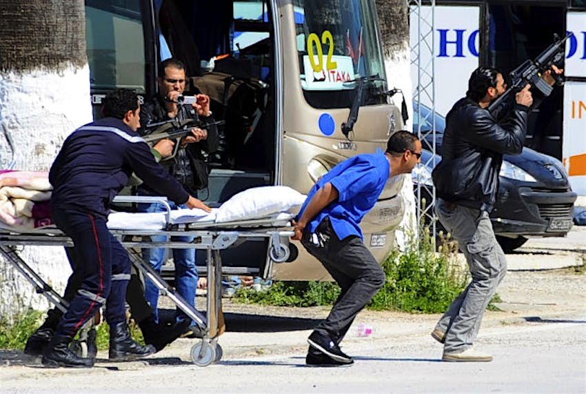 Travel News - tunisia 2 Escorted by security forces, rescue workers pull an empty stretcher outside the Bardo museum.