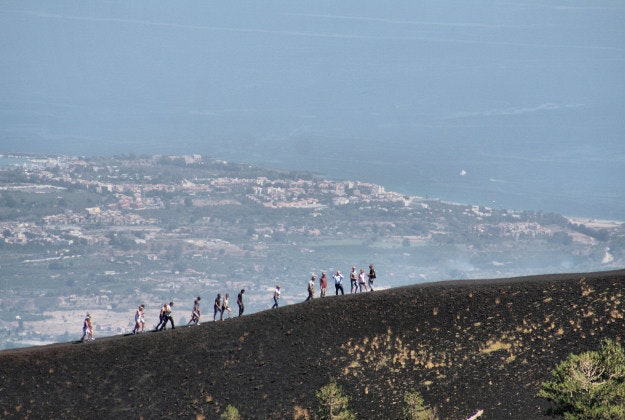 Tourists exploring one of Etna's many craters.