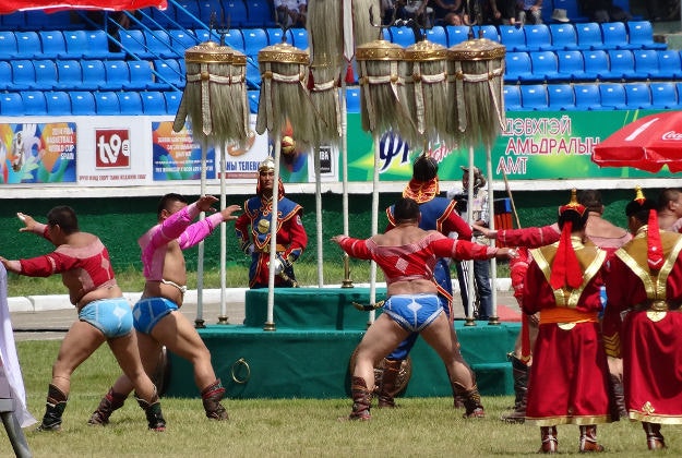 Wrestlers saluting the Yak Tail Banners at the Naadam Festival, Mongolia.