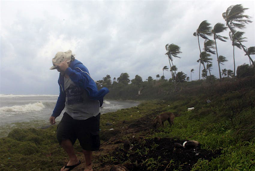 Travel News - tropical storm erika A man walks on the shore against strong winds backdropped by a rough sea as Tropical Storm Erika moves away from the area in Guayama, Puerto Rico.