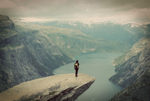 A hiker stands on Norway's Trolltunga.