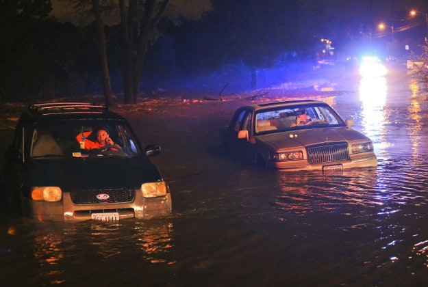 Ashley Hill, left, and John Joplin make calls from their car as they wait to be rescued Tuesday, Sept. 29, 2015, in Roanoke, Va. Steady rains have forced the early closure of schools and flooded streets from Southside Virginia to the Shenandoah Valley and surrounding areas.
