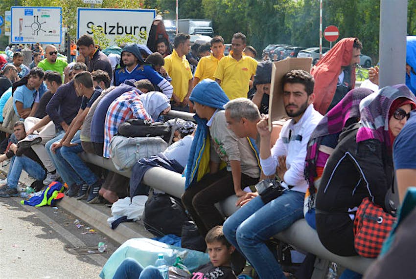 Travel News - europe migrants 1 Refugees rest on the roadside after police stopped them near the border between Austria and Germany, in Salzburg, Austria, last month