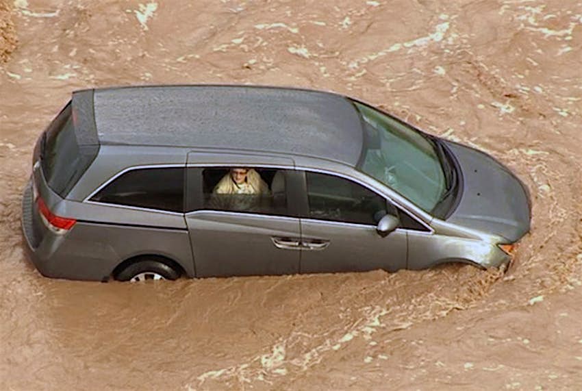 Travel News - flood2 Firefighters drove a truck into the flooded wash to a spot near the woman's vehicle and walked through knee-high water to the car, where they gave the woman a flotation vest.