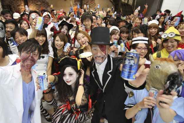 In this Oct. 24, 2015 photo, participants in costumes pose for a photo during a Halloween party event in Tokyo. 