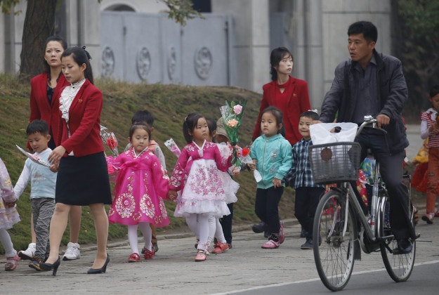 Children walk with decorative flowers for the upcoming anniversary celebrations in Pyongyang, North Korea, Thursday, Oct. 8, 2015. The country is in high gear with preparations for the 70th anniversary of the founding of the North Korea Workers' Party on Oct. 10, 2015