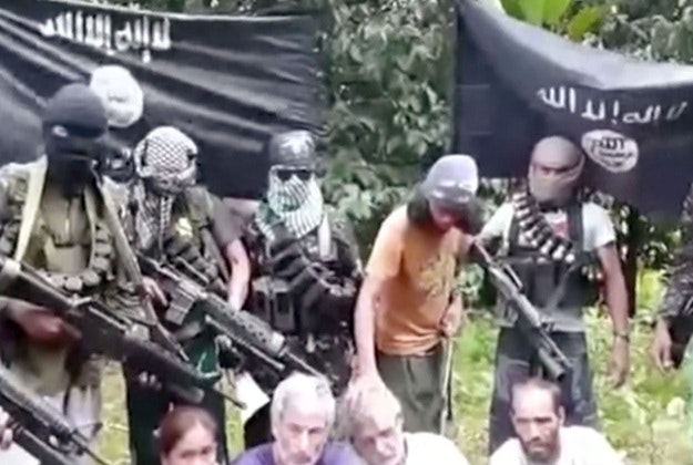This frame grab from militant video purportedly shows armed militants surrounding two Canadians, a Norwegian and a Filipino woman abducted last month in the Philippines. 