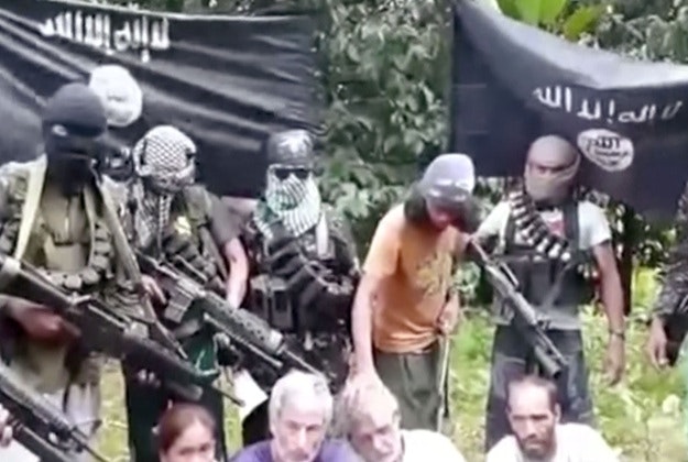 This frame grab from militant video purportedly shows armed militants surrounding two Canadians, a Norwegian and a Filipino woman abducted last month in the Philippines.