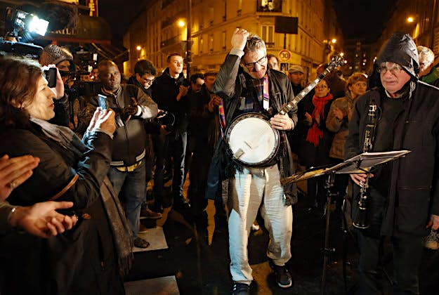 Travel News - Paris tributes 1 Jazz musicians acknowledge applause in front of "The Petit Cambodge" Restaurant, one of the sites of most deadly of six coordinated extremists attacks, in Paris.