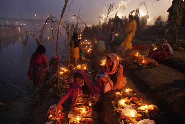 Indian Hindu devotees perform rituals at sunset on the banks of the Yamuna River during the Chhath Puja festival in New Delhi, India, Tuesday, Nov. 17, 2015. During Chhath, an ancient Hindu festival, rituals are performed to thank the Sun god for sustaining life on earth. 