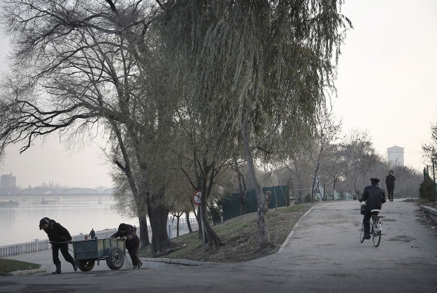 North Korean women pull a cart up a slope as others cycle and walk on a path next to the Taedong River on Monday, Nov. 30, 2015, in Pyongyang, North Korea. The Taedong River is the second longest river in North Korea. 