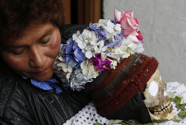 A woman carries a decorated human skull or "natitas" outside the Cementerio General chapel, during the Natitas Festival celebrations, in La Paz, Bolivia.