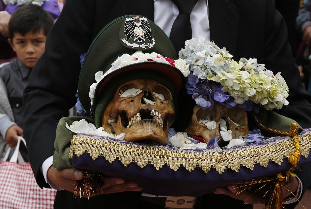 A man carries decorated human skulls or "natitas" outside the Cementerio General chapel, during the Natitas Festival celebrations, in La Paz, Bolivia. 